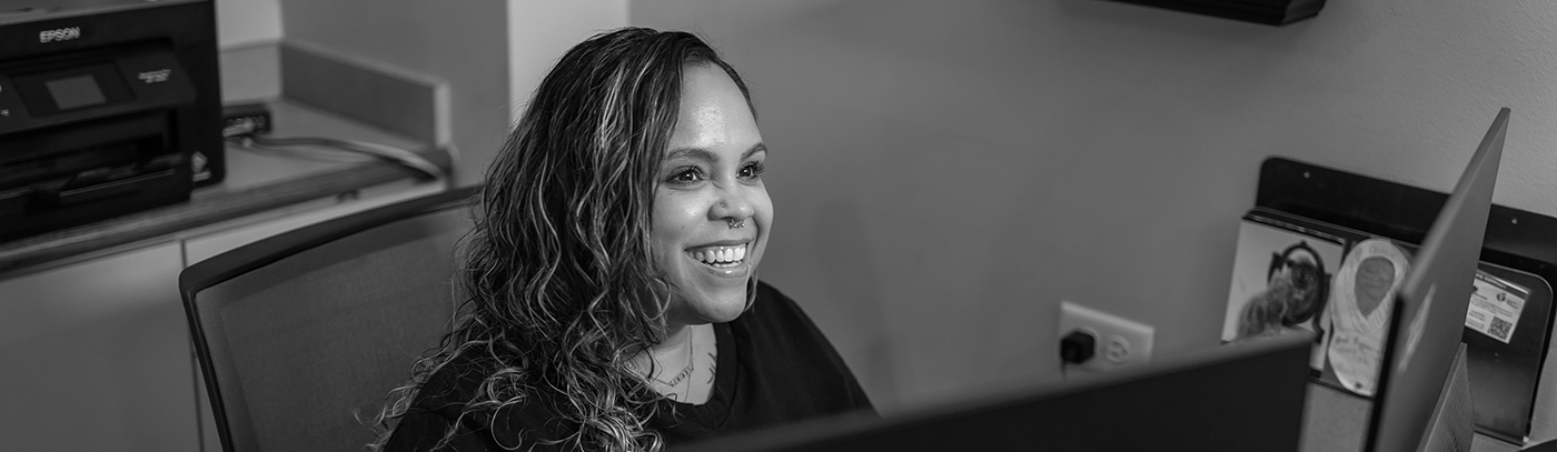 Dental team member at the front desk smiling at a patient